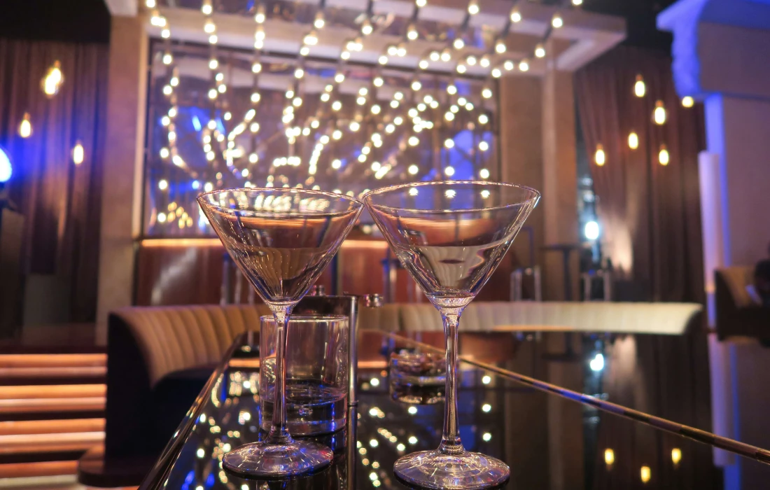 two cocktail glasses on a bar in a sophisticated club bar